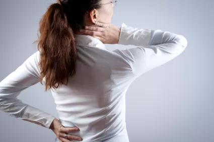vrouw voelt aan haar rug en nek